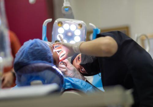 Dentist performing bone graft procedure after tooth extraction.