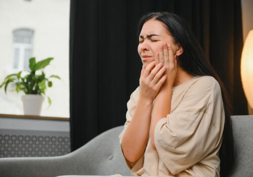 Woman with toothache holding her jaw in pain