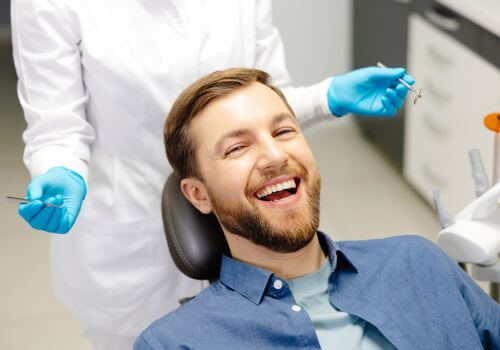 Man smiling in dental chair after holistic dentistry services