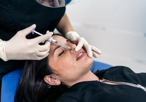 Dentist administering Botox near a woman's mouth for smile enhancement