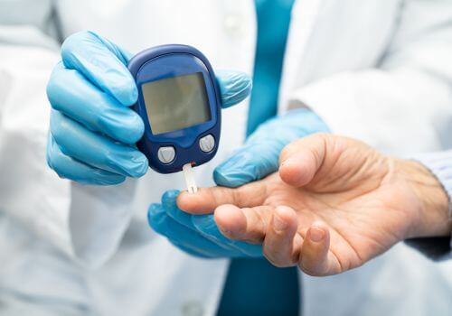 Doctor using tool to check blood sugar for diabetes