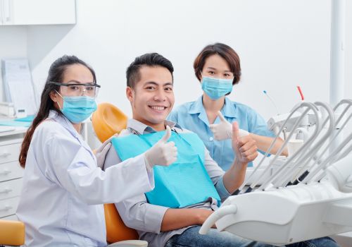 Dentist and patient in dental chair giving a thumbs up