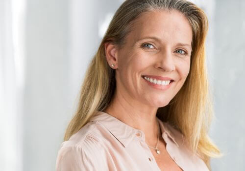 Adult woman smiling with dental work completed.